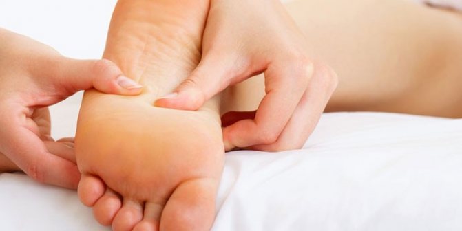 Женщине делают массаж стопы